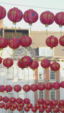 Vertical-Video-Close-Up-Of-Colorful-Paper-Lanterns-Hung-Across-Street-To-Celebrate-Chinese-New-Year-2023-In-London-UK-1